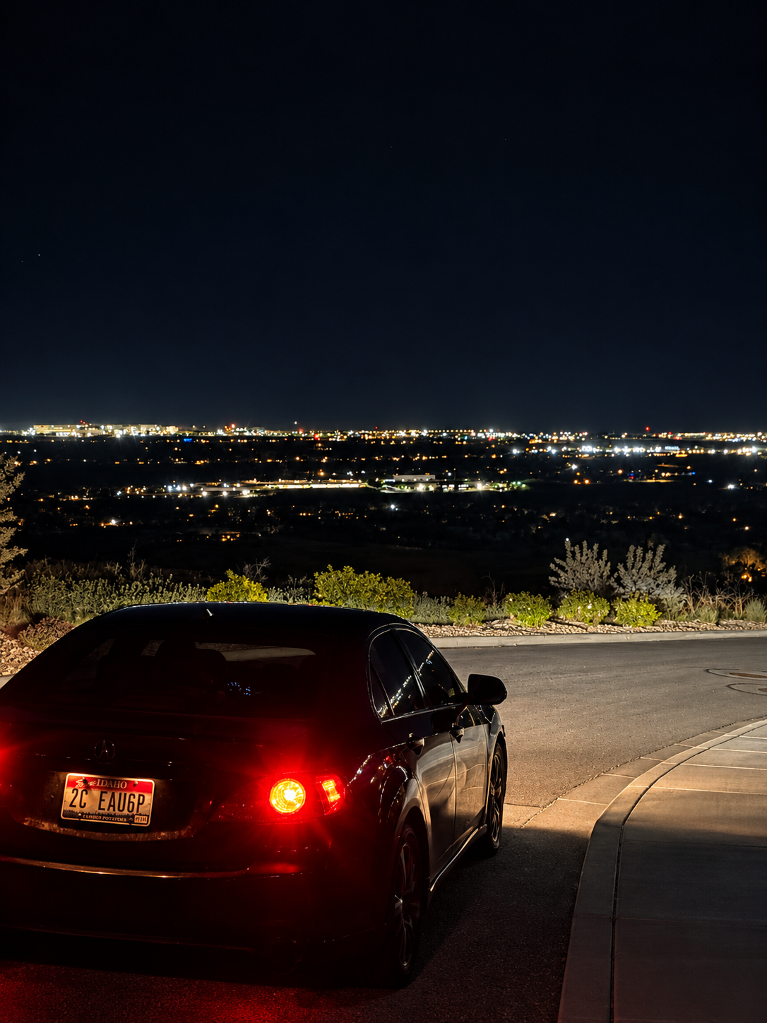 Freshly detailed black Acura overlooking the city at night